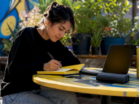 Woman writing content ideas at home studio desk