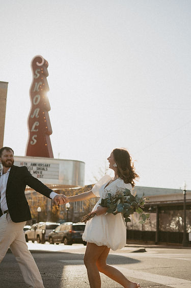 couple holding hands crossing the street in a busy city