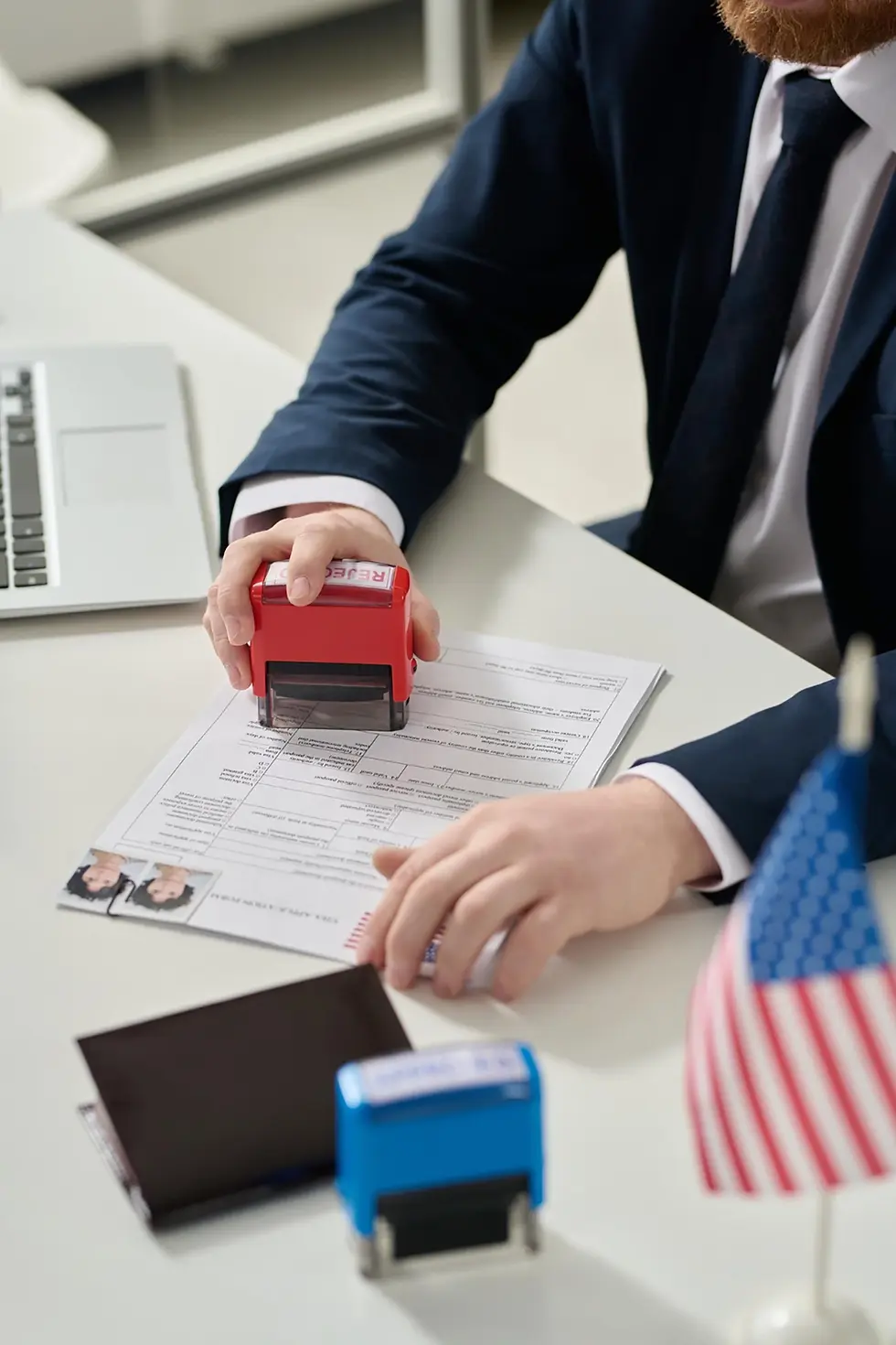 Person stamping official document, passport, USA flags