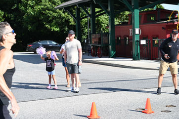 Adults and a child stand outdoors near orange cones