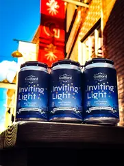 Three inviting Light cans with blue branding and visible text on a building.