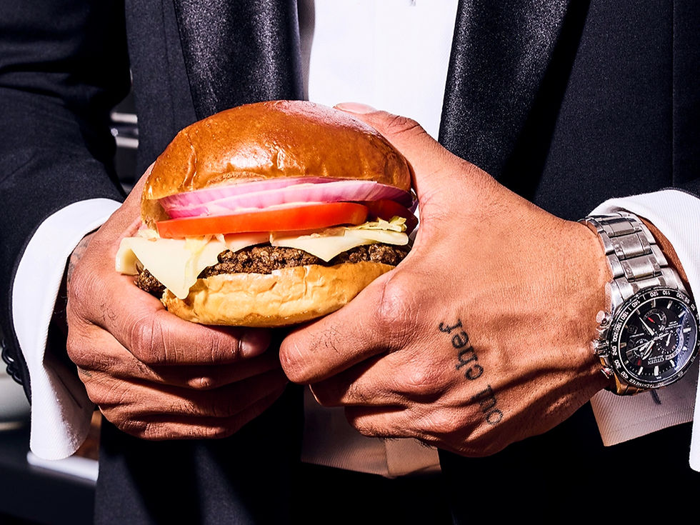 Hands holding a delicious burger, with tomato, onion, and cheese. dev-chef-ashish