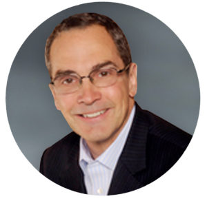 Portrait of a smiling male team member wearing glasses.