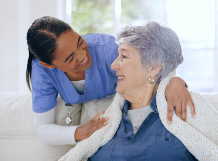 Smiling caregiver gently comforting an elderly woman