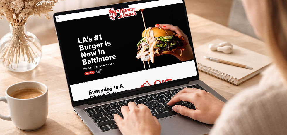 Person typing on laptop at a desk, viewing Wanna Smash burger ad reading LA's #1 Burger Is Now In Baltimore.