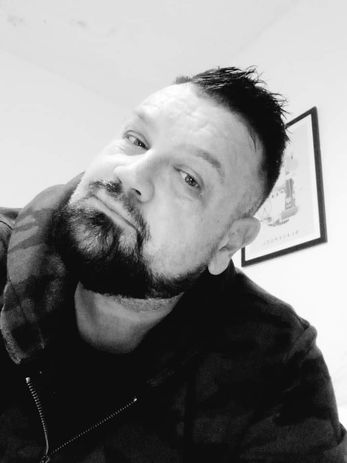 Man with beard tilting head in black and white portrait