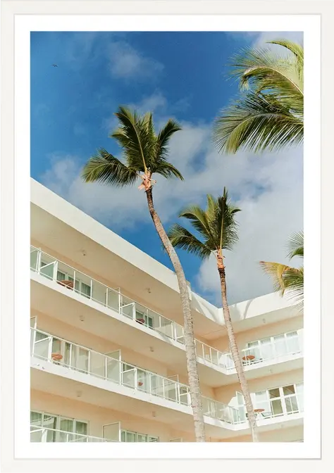 Palm trees and building against blue sky. Palm 012. Resort setting.