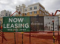 Now Leasing banner for The Thornton building under construction