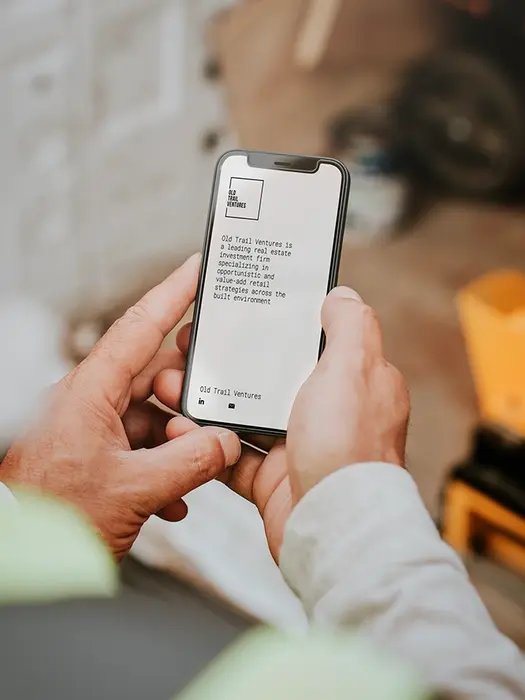 Man holding a phone with text displayed, construction work in the background.