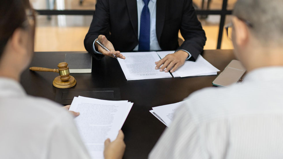 Lawyer explains documents to a couple at a desk with papers