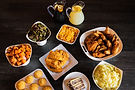 Fried chicken, sides, cornbread, and drinks on a table.