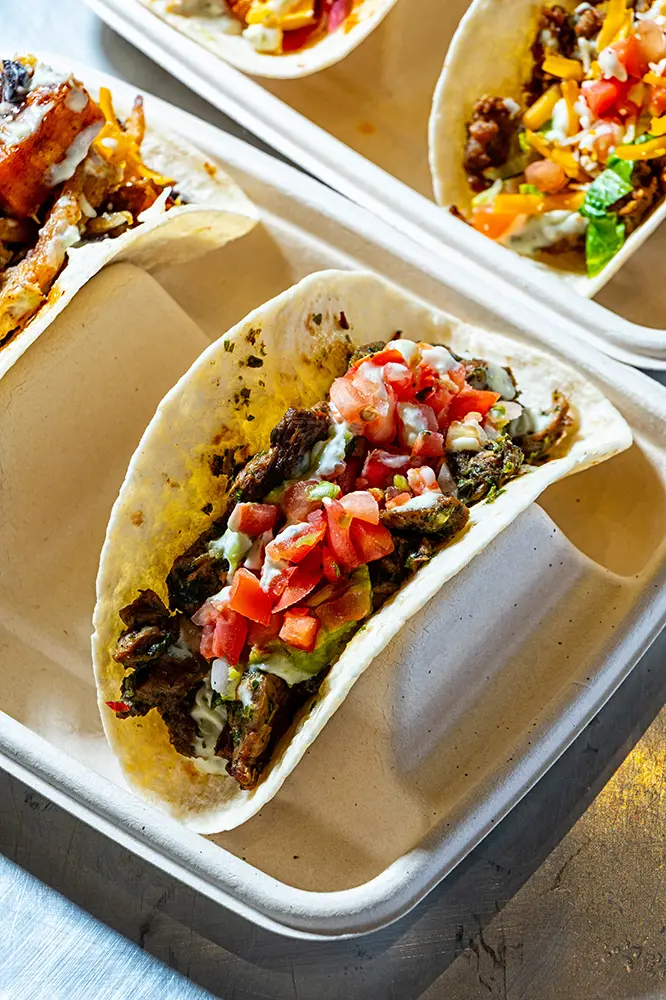 Close-up of tacos in a tray with fresh salsa and vegetables, Knockout Takos
