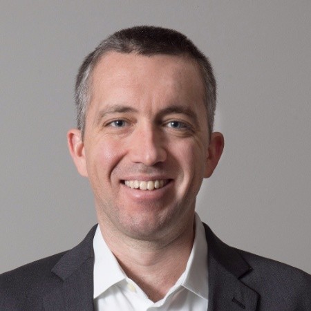 Smiling professional from an AI innovation company.