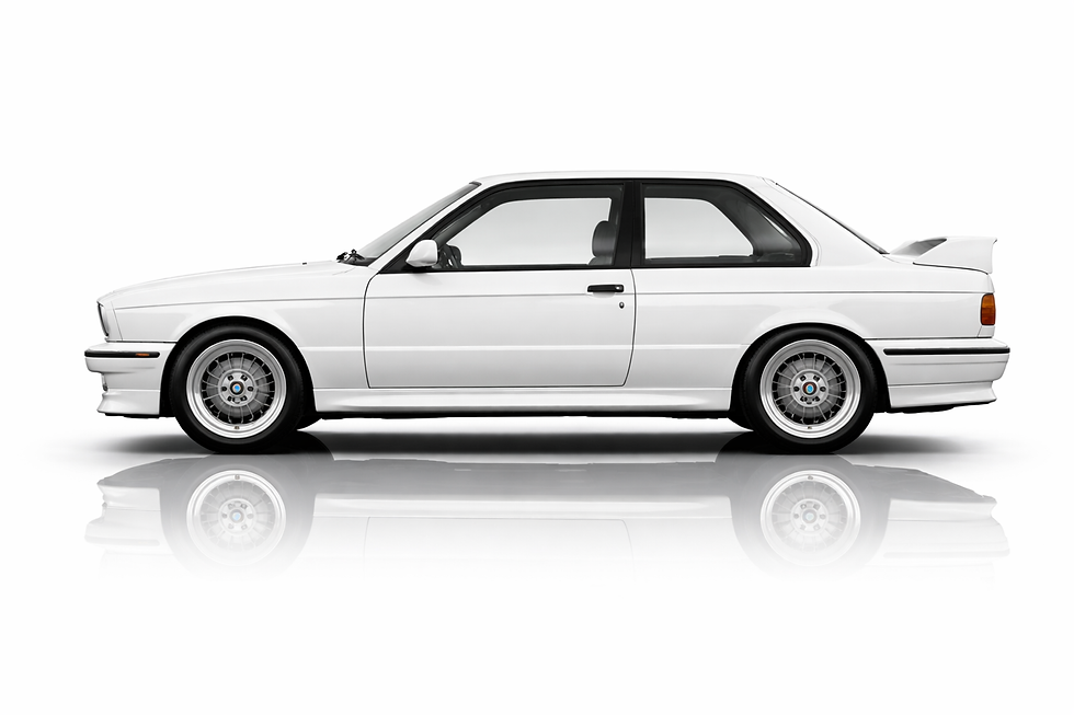 Profile of a white BMW E30 M3 coupe with rear spoiler.
