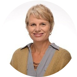 Smiling woman with short blonde hair in a tan cardigan