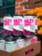 Hazy Bones beer cans stacked with Hazy Bones text in a carton outdoors.