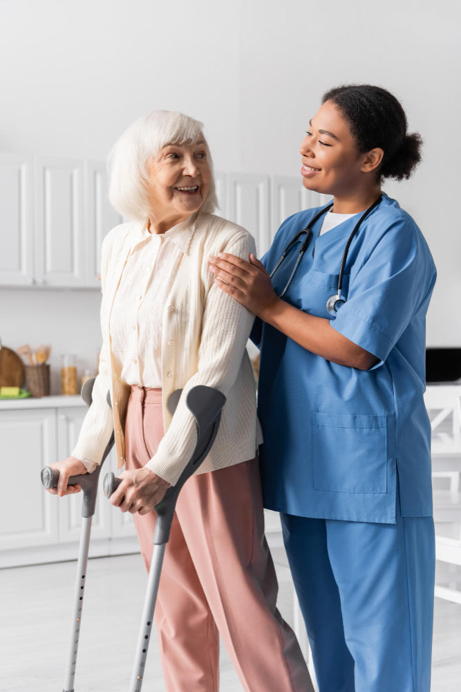 Caregiver helps elderly woman with crutches