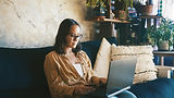 Woman sitting on a couch using a laptop