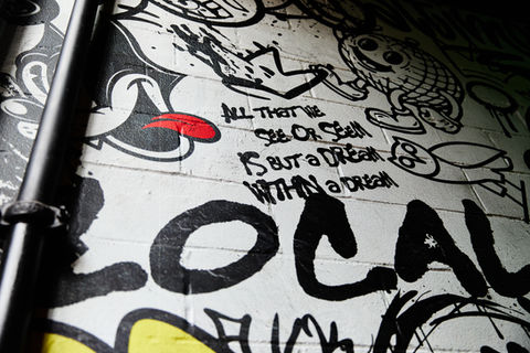 Graffiti art with the words, "All that we see or seem is but a dream within a dream."