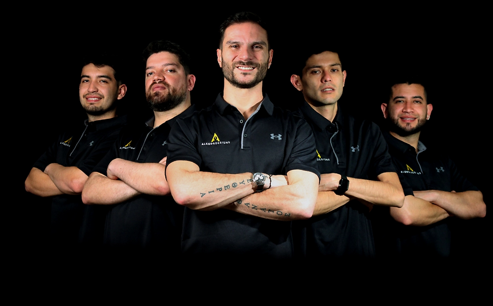 Team portrait of smiling men wearing black shirts posing together. alekos designs.