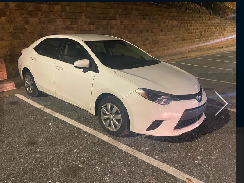 White Toyota Corolla parked in a lot at night. Dash Auto