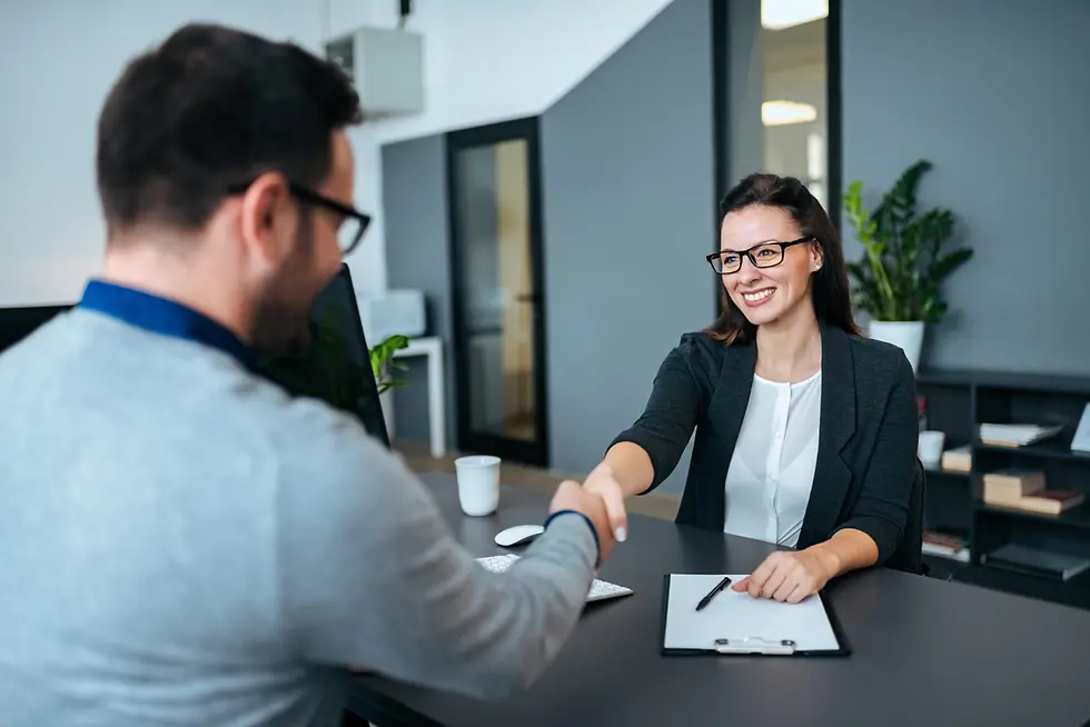 Smiling woman and man shaking hands during job interview
