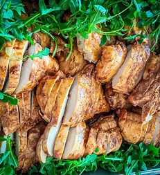 Sliced grilled chicken with fresh arugula