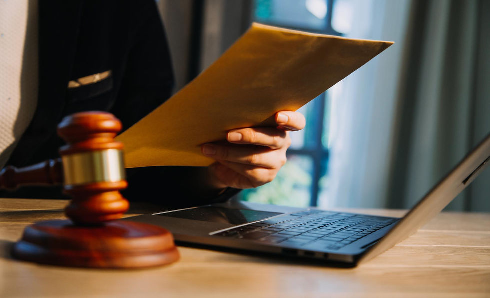Legal gavel, person holding envelope, and laptop