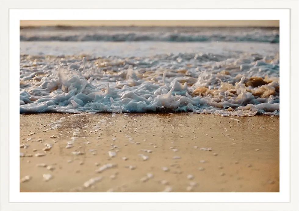 Waves crashing on the shore with white foam and wet sand Palm 012 background.