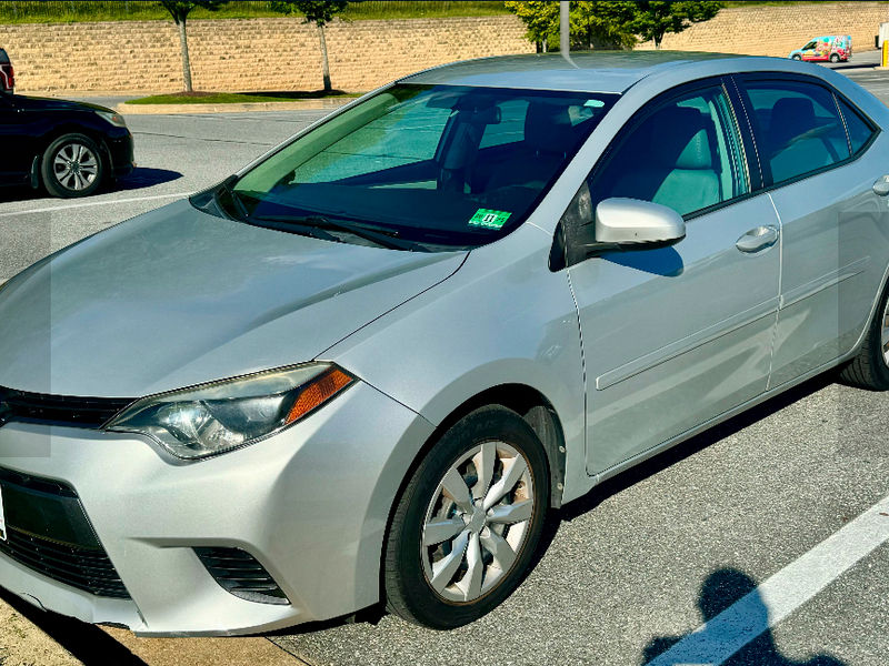 Silver Toyota Corolla parked on the street, Dash Auto nearby.