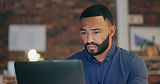 Bearded man concentrating on laptop screen