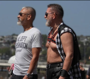 Two men in sunglasses during a Pride Month celebration.