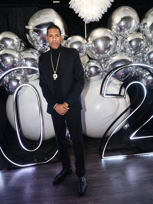 Man standing in front of 2022 balloons and decor. dev-blk-swan