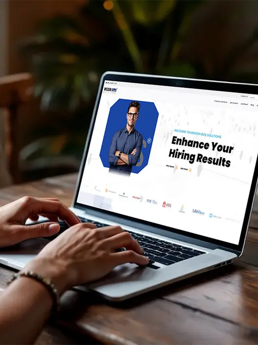 Hands typing on laptop with "Enhance Your Hiring Results" on the screen.