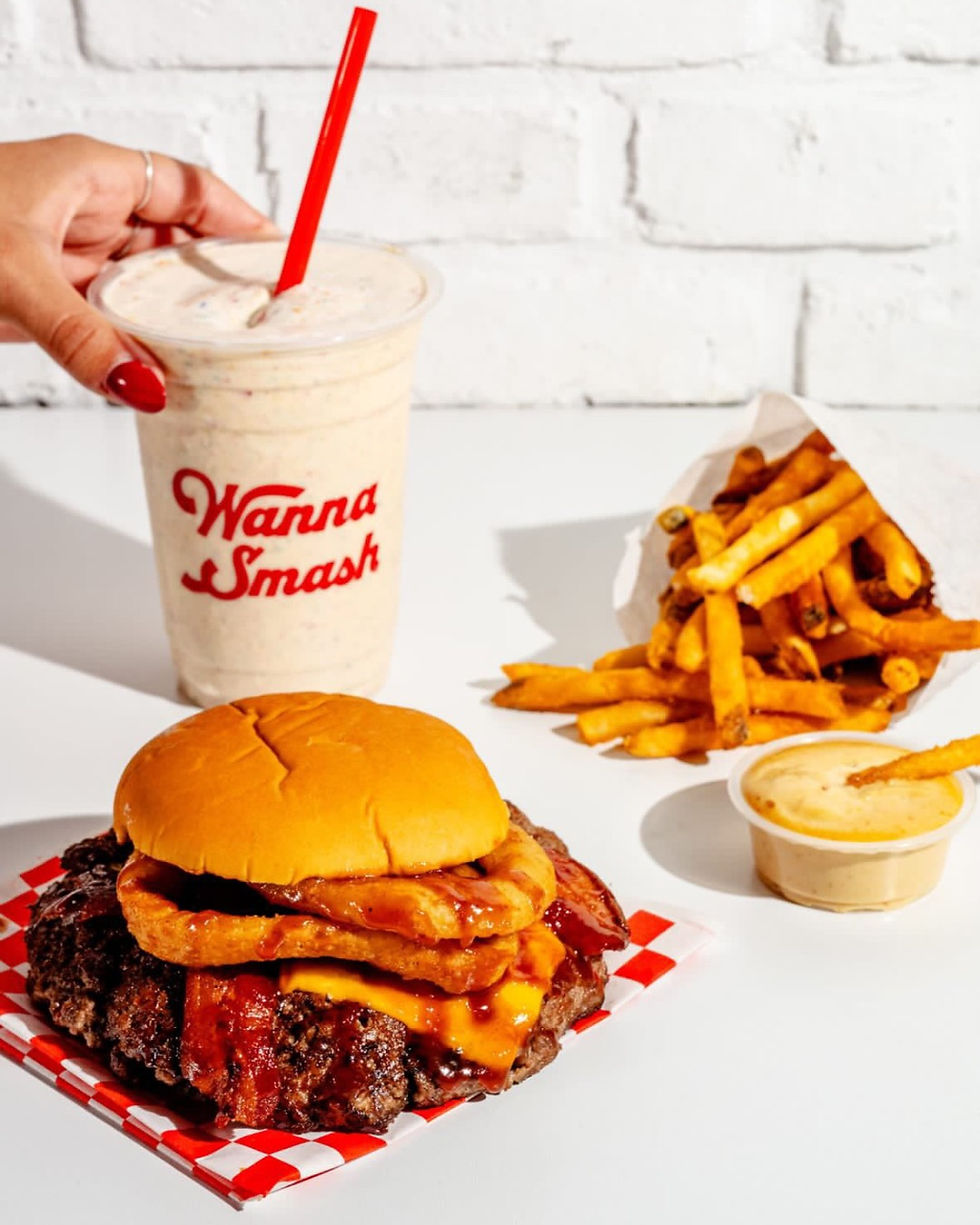 Burger with onion rings and bacon, milkshake "Wanna Smash?", fries, dipping sauce.