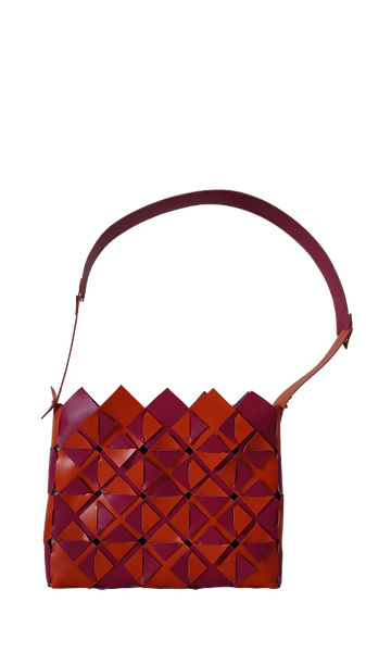 Geometric woven handbag in red and orange with a wide strap, displayed against a transparent background.