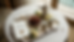 Top-down view of a guest welcome tray with dates, Arabic coffee cups, and wedding flowers.