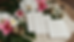 Close-up view of wedding itinerary cards beside tropical flowers.
