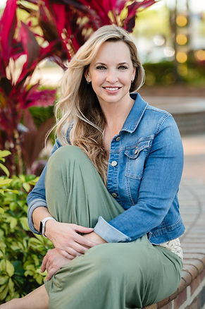 Blonde woman wearing jean jacket one leg stretched to her chest