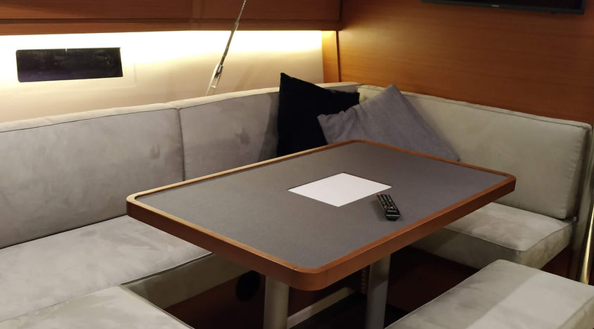 Boat interior with gray upholstered seating and wooden table