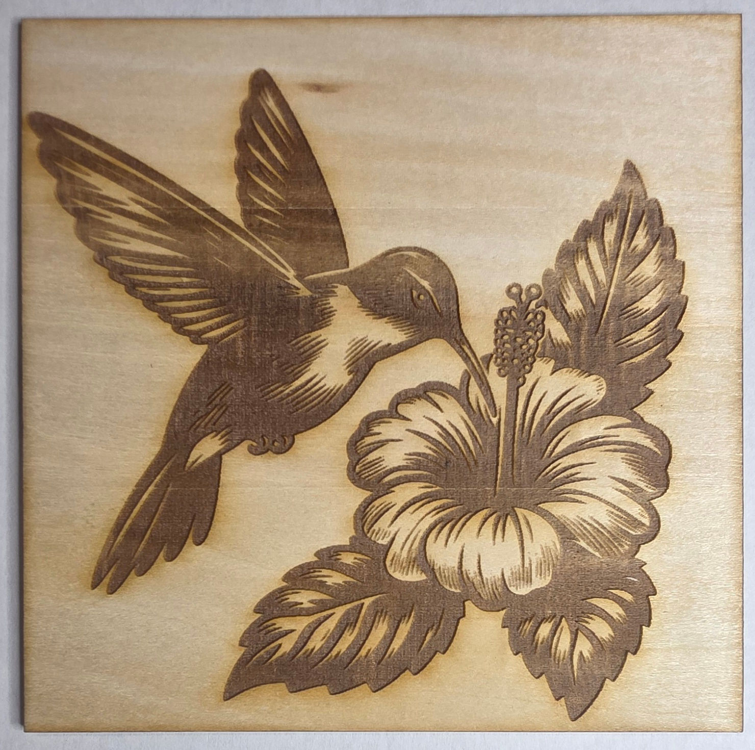 Wood etching of hummingbird and flower