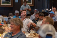 Golf participants laughing in the crowd during the live auction.JPG