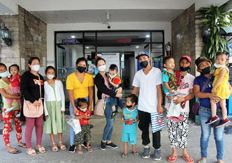 Parents and children with cleft posing outside of a hospital after surgery.