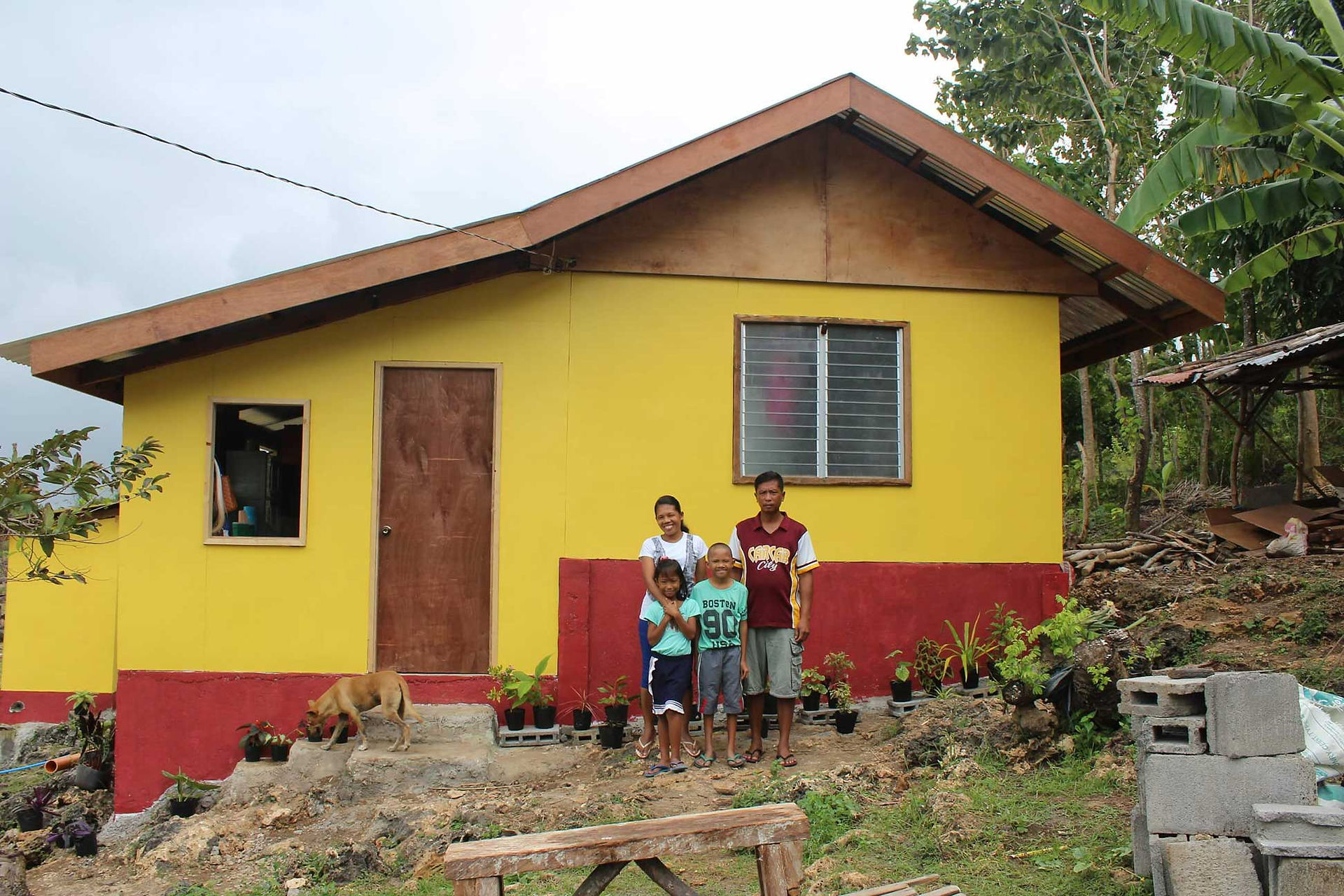 A thankful family with their new home made by a foundation in the Philippines. 
