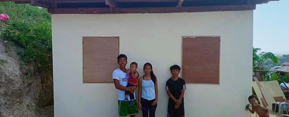 Filipino family who lost their home in Typhoon Odette standing in front of new house