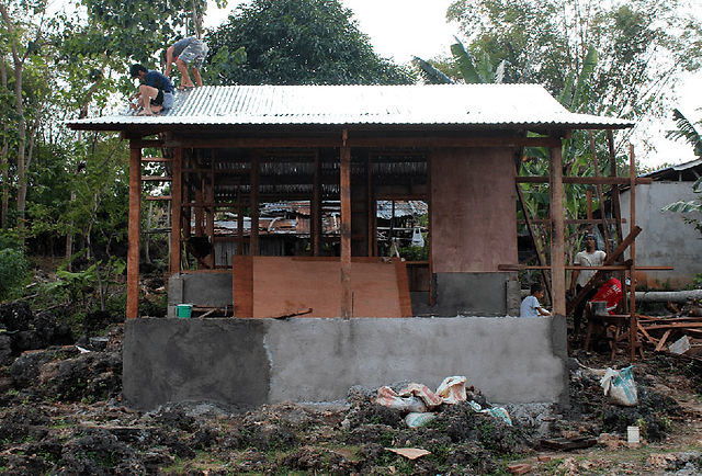 Construction Workers finishing the roof. 