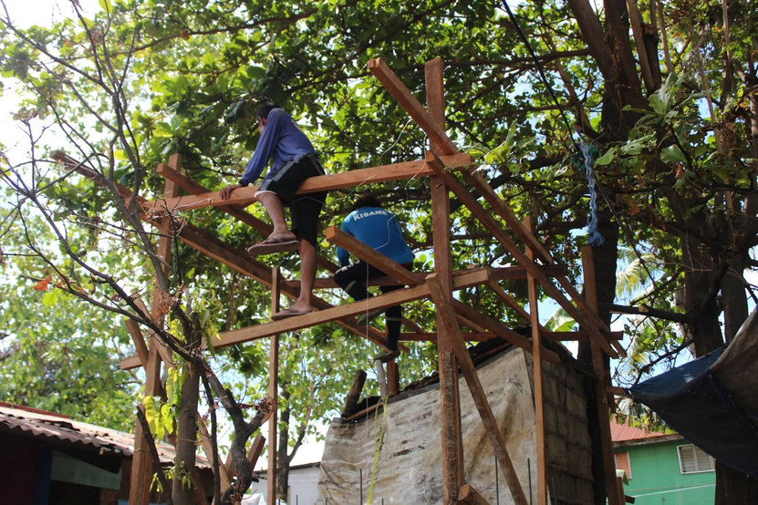 Two workers working on a new toilet for a Filipino family with the help of the charity