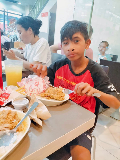 Young Filipino boy having lunch after a visit to the doctor