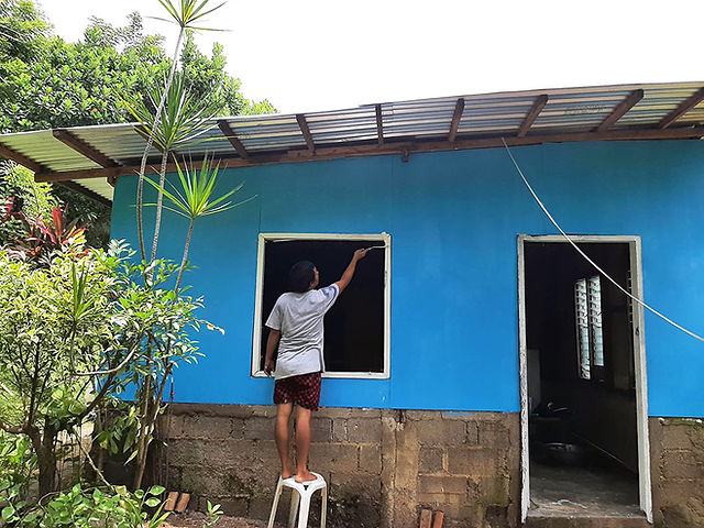 Worker working on a the repair of the window destroyed by a typhoon