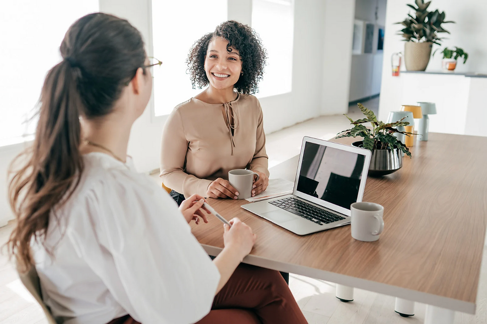 Dos compañeras de trabajo charlando en su oficina.